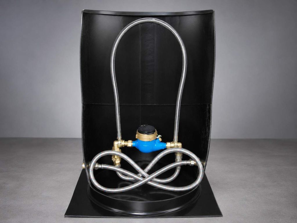 Cutaway plastic water meter pit with the meter and pipework installed