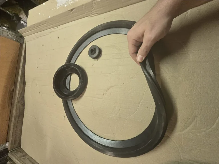 Worker handling a large-diameter vulcanized rubber flange gasket