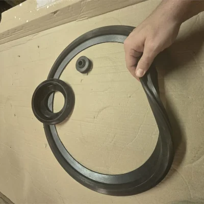 Worker handling a large-diameter vulcanized rubber flange gasket